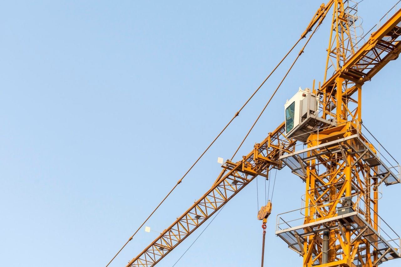 Worker with construction tools amid steel framing