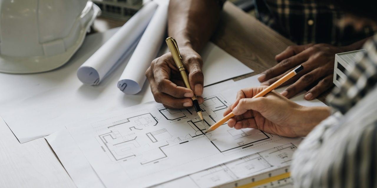 Team marking up an architectural blueprint